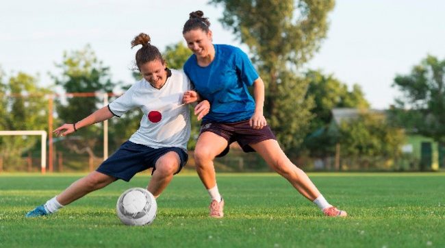 Two girls plying foot ball game